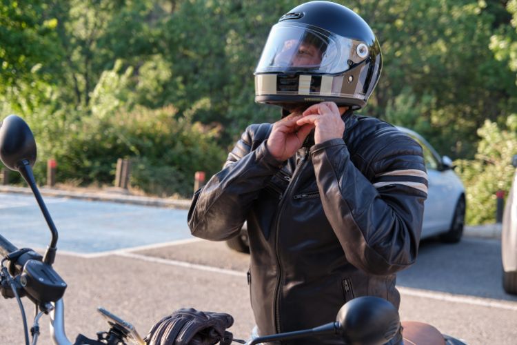 rider buckling up helmet before a motorcycle ride