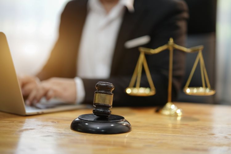 criminal defense lawyer and scales of justice in the background and gavel in foreground