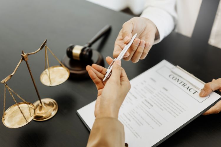 lawyer letting client sign a contract