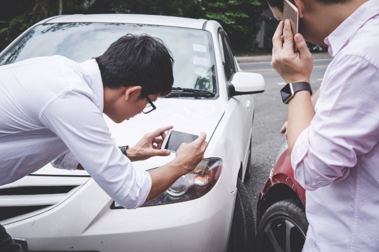 driver taking a photo evidence of car accident