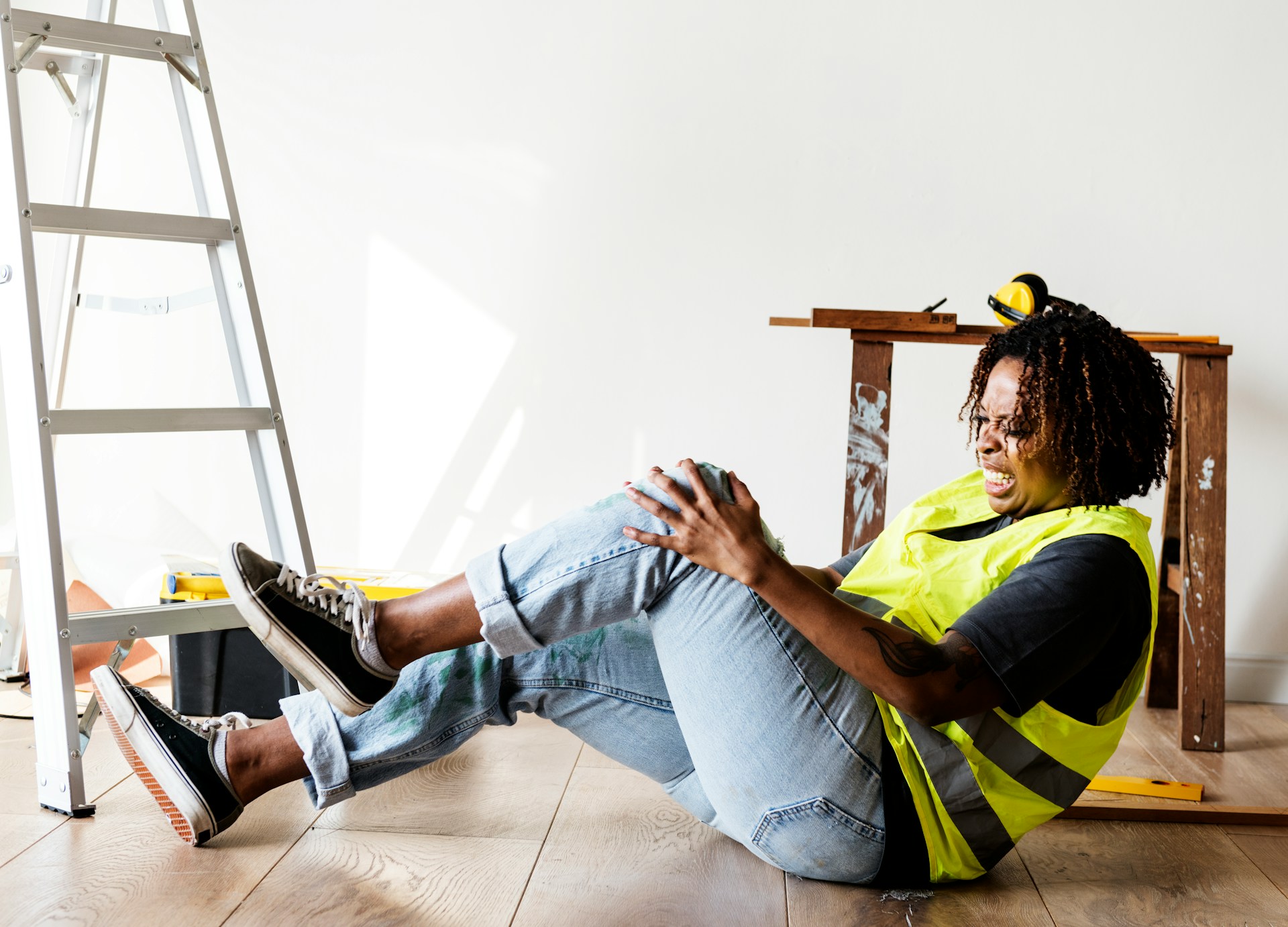 How to Gather Evidence for a Personal Injury Claim in Arizona Worker in safety vest experiencing knee injury on construction site in Mesa, Arizona, highlighting personal injury claim context.