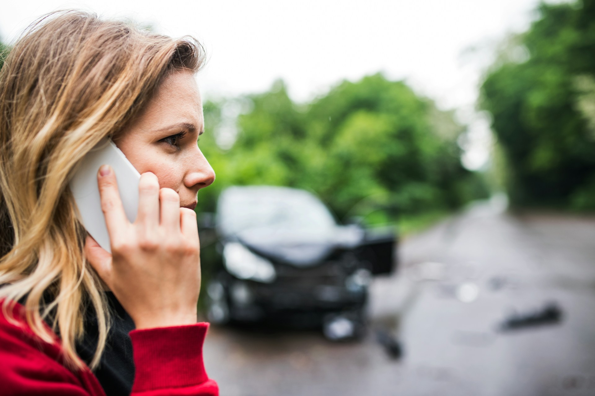 Steps to Take After an Accident in Bullhead City Woman on phone after car accident on a road, emphasizing steps to take after an accident in Arizona.