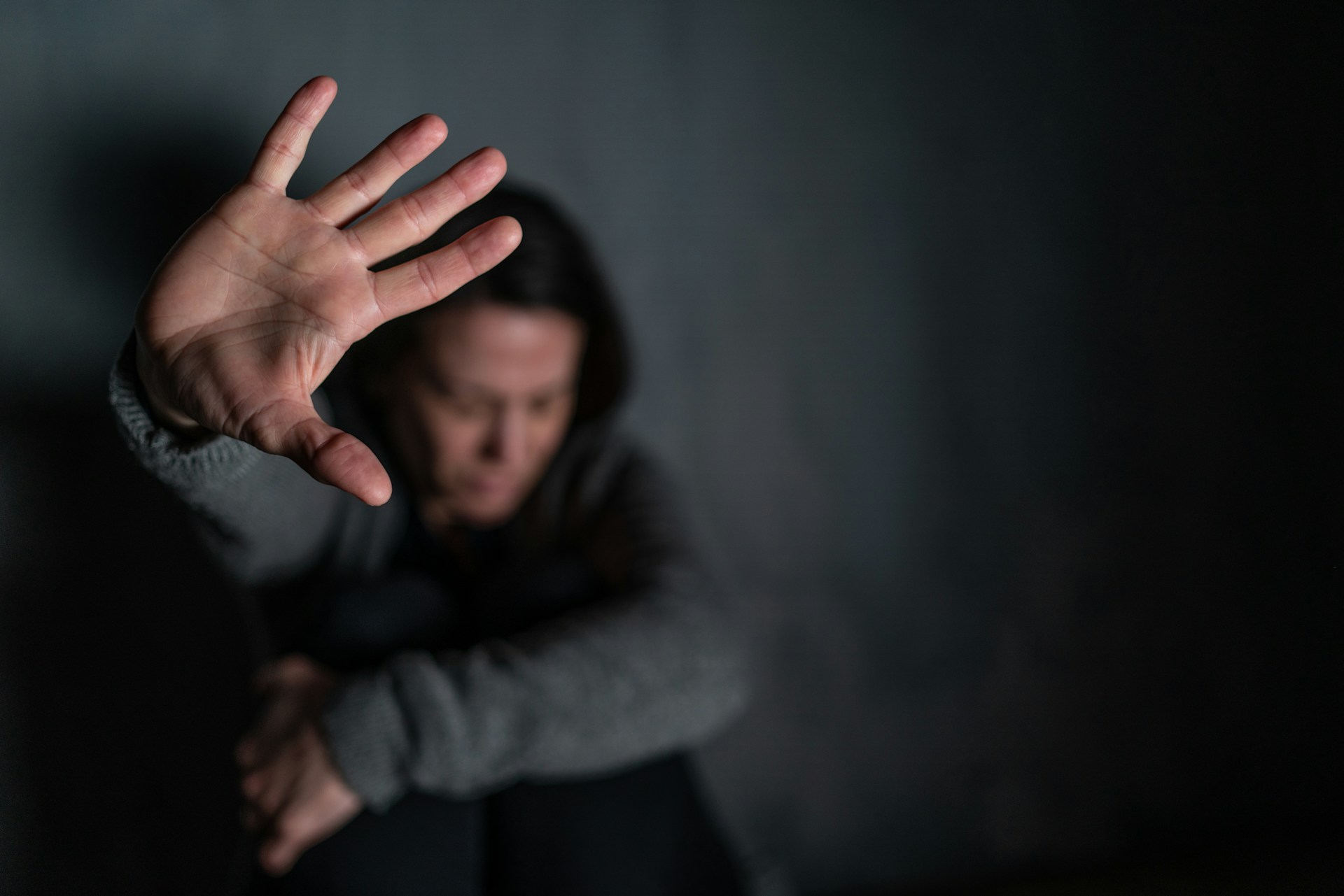 Person with outstretched hand in a protective gesture, representing themes of domestic violence and legal support in Arizona.