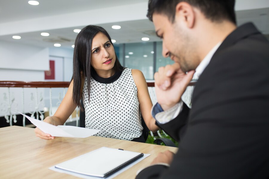 Attorney consultation in Mesa, Arizona, discussing legal documents with a concerned expression during a meeting.